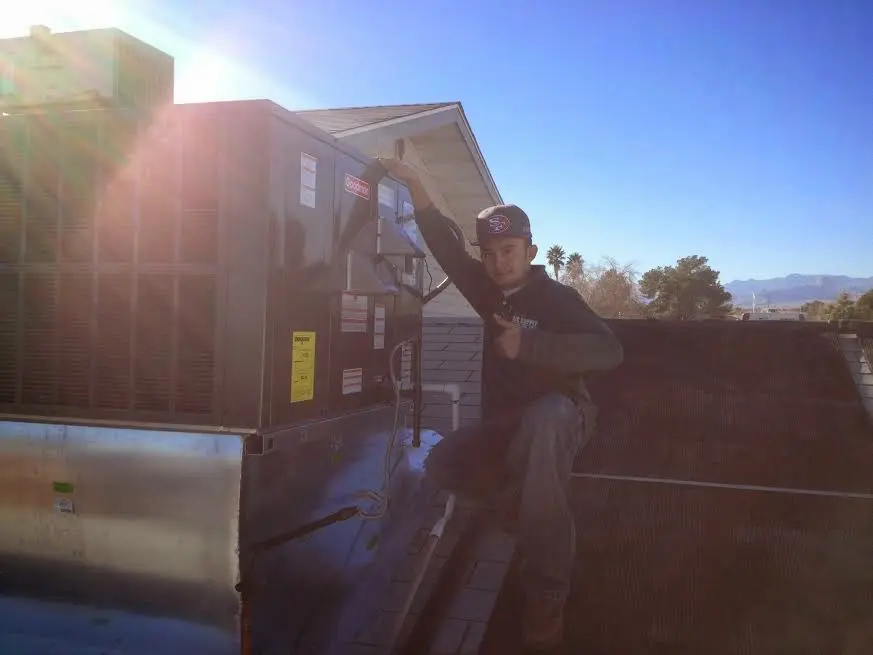 HVAC technician performing AC Tune-Up on a rooftop unit in Cotati